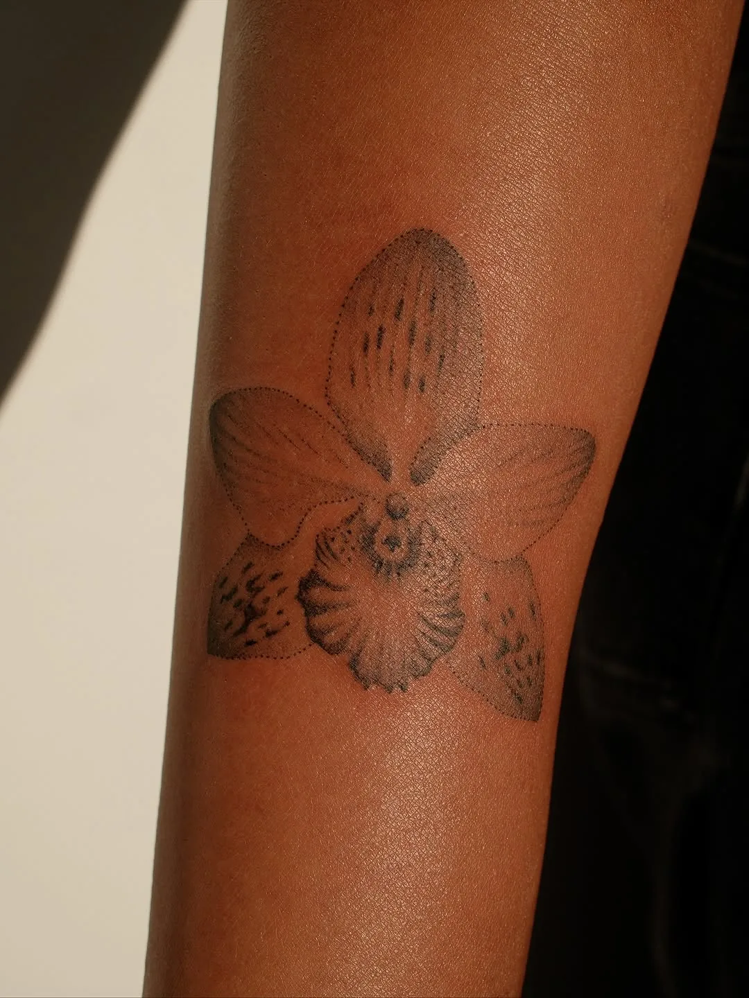 Dotwork orchid tattoo on a forearm